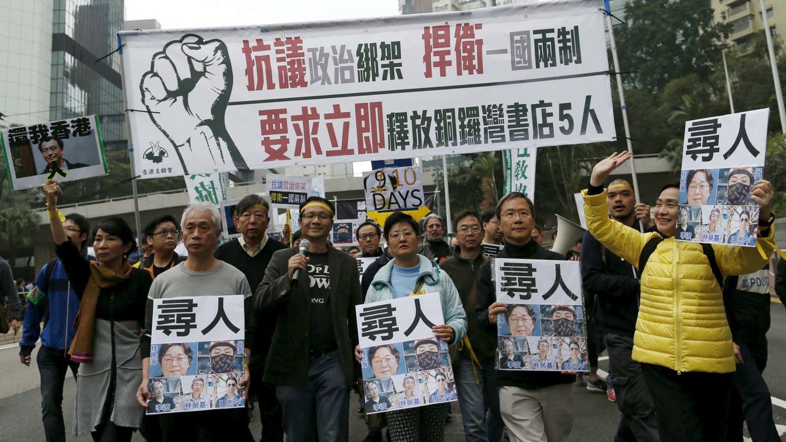 Demonstrators hold up portraits of five missing booksellers in Hong Kong.