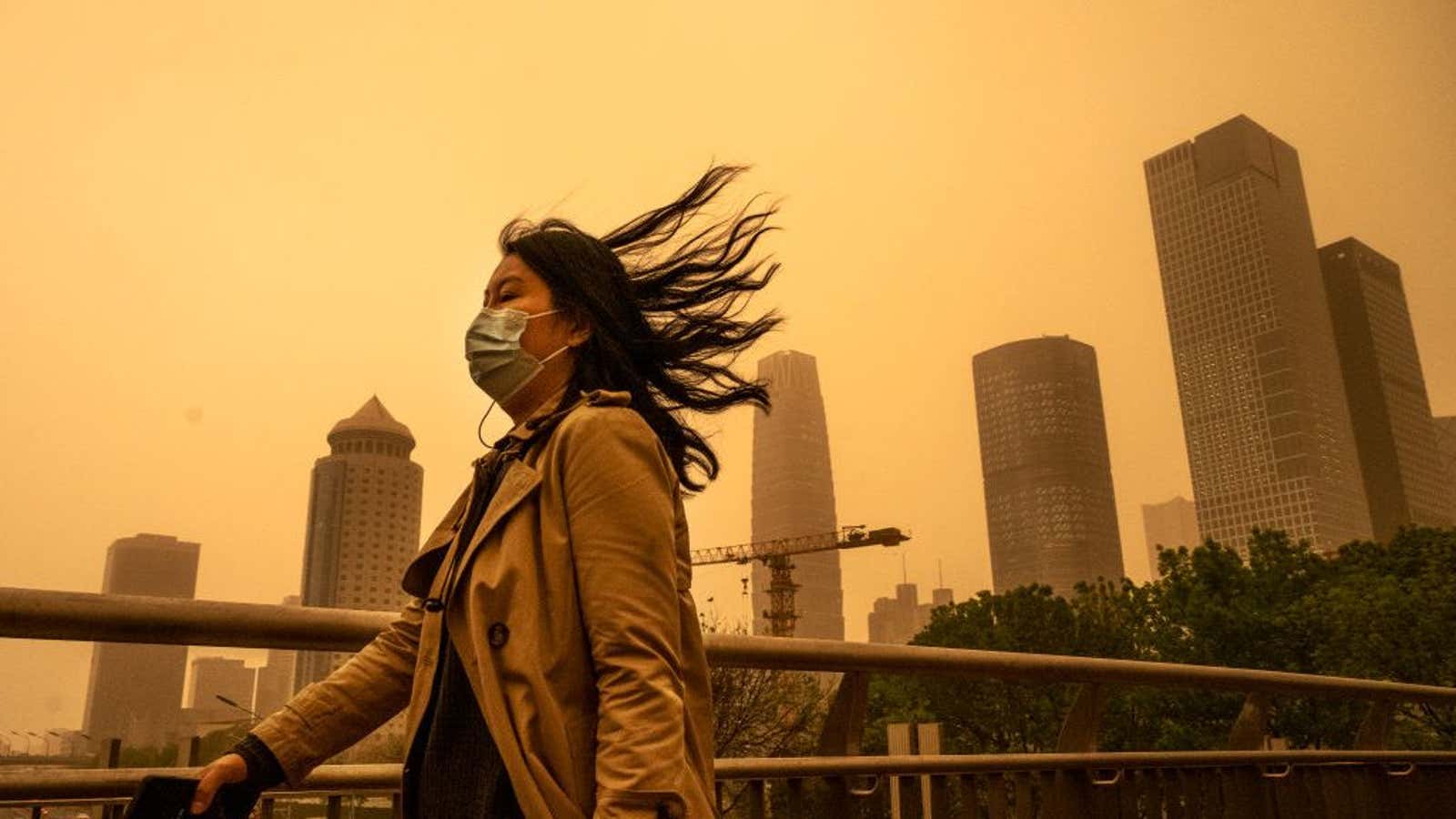 A woman wears a protective mask during a seasonal sandstorm in Beijing.