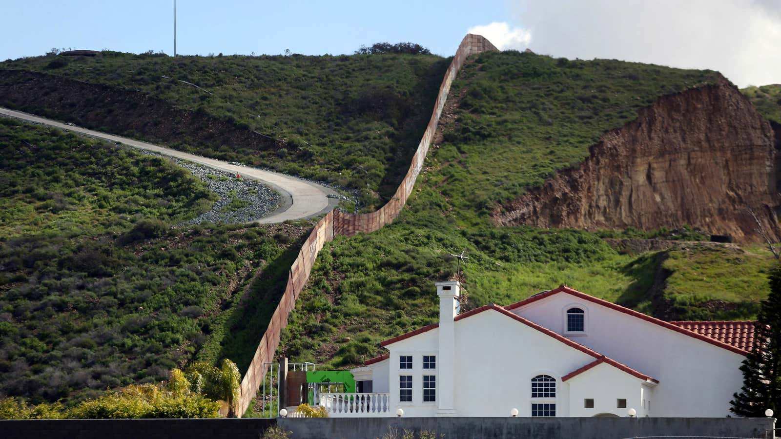 A house stands next to a section of the border fence separating Mexico and the United States, in Tijuana, Mexico in 2017.