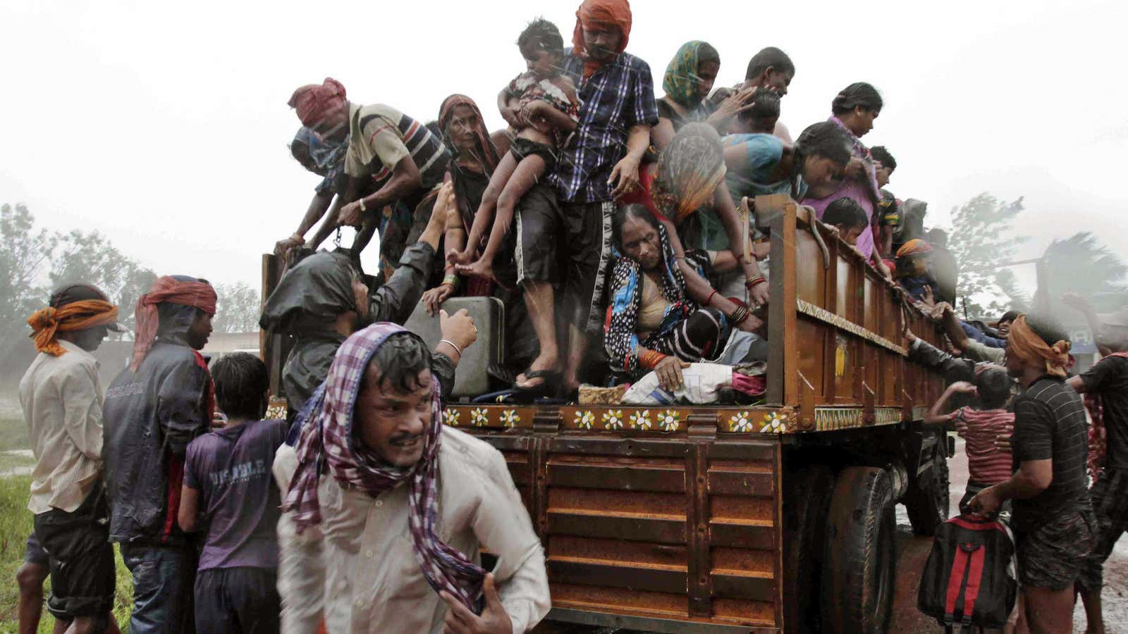 Evacuees get down from a truck at a relief camp near Berhampur, India, on Oct. 12.