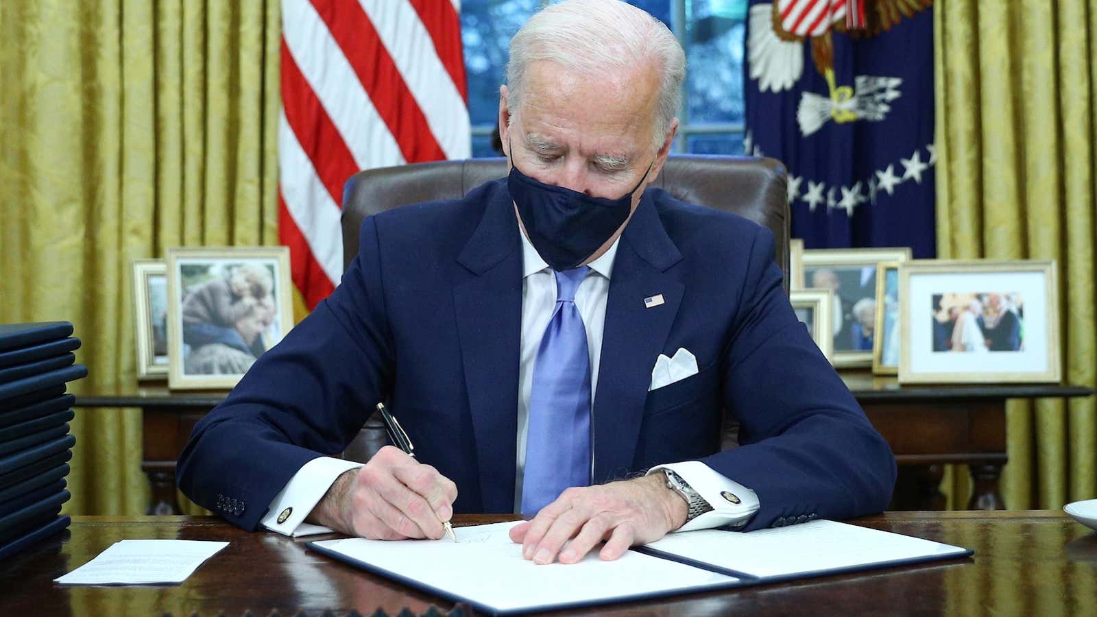 U.S. President Joe Biden signs executive orders in the Oval Office of the White House in Washington, after his inauguration as the 46th President of…