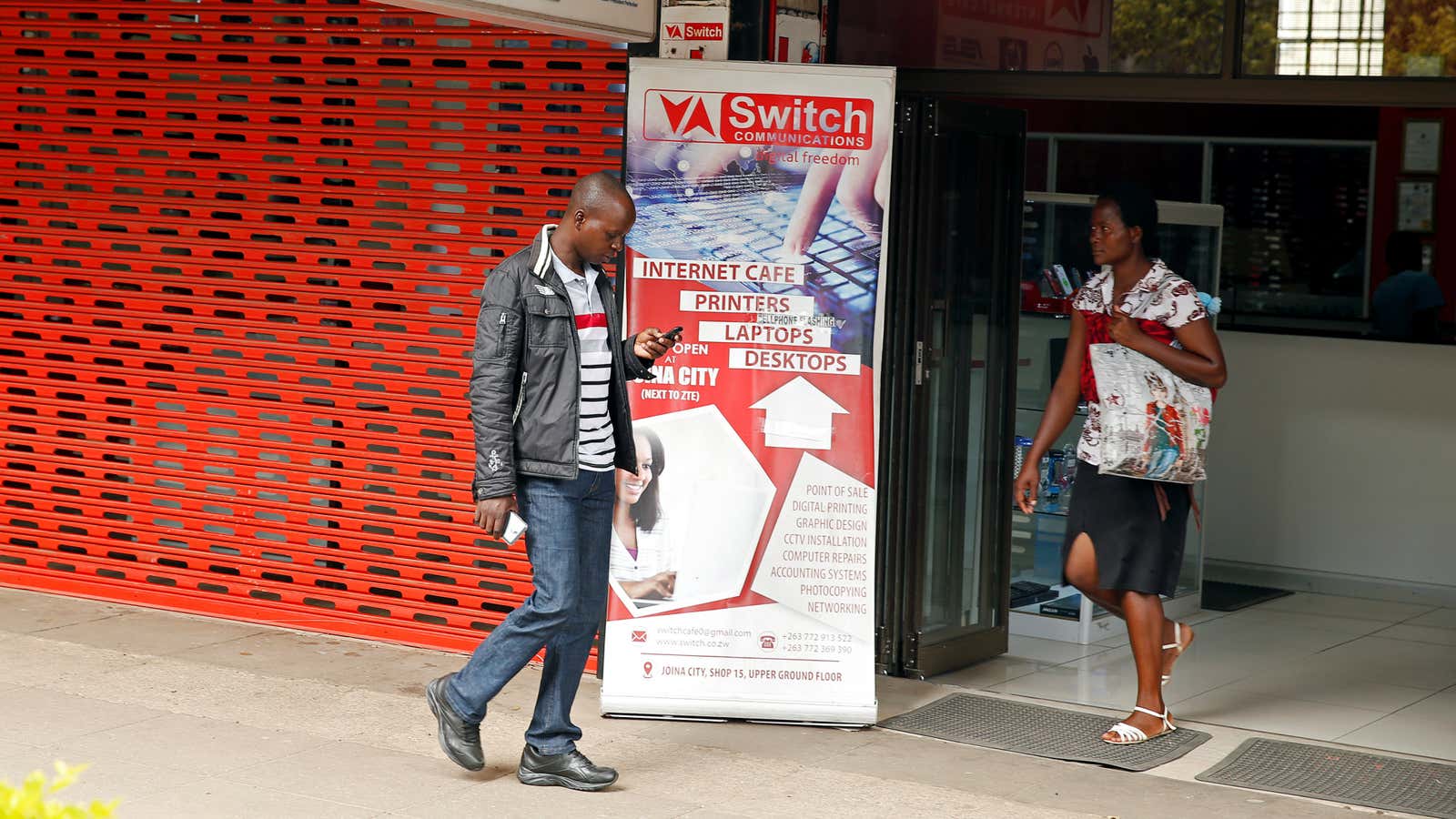 A man checks his mobile phone outside an internet cafe in Harare, Zimbabwe, January 21, 2019. REUTERS/Philimon Bulawayo