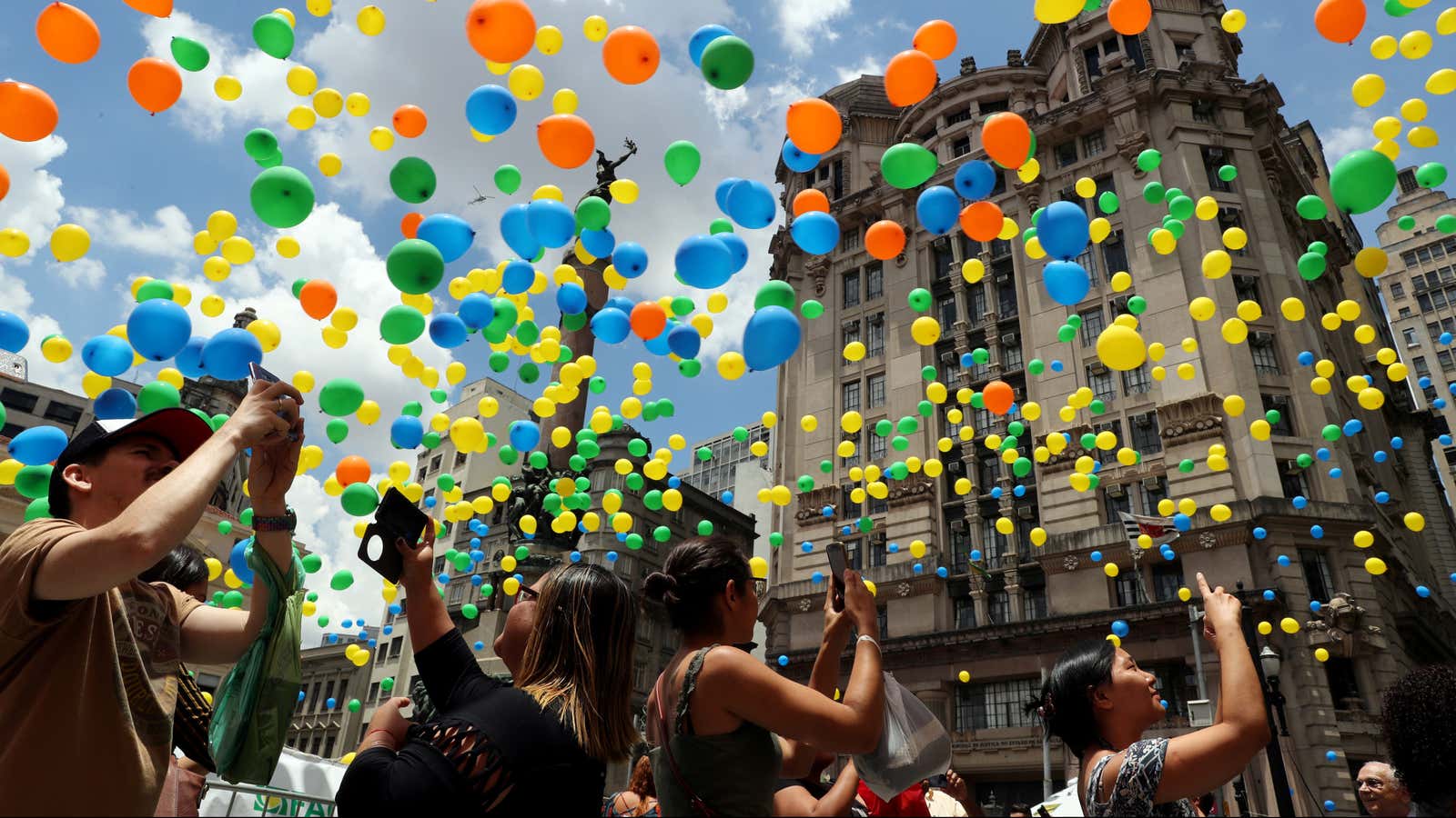 People take pictures of balloons being released in the sky of downtown Sao Paulo as part of year-end celebrations, Sao Paulo, Brazil December 28, 2018. REUTERS/Paulo Whitaker – RC1A34C1B300