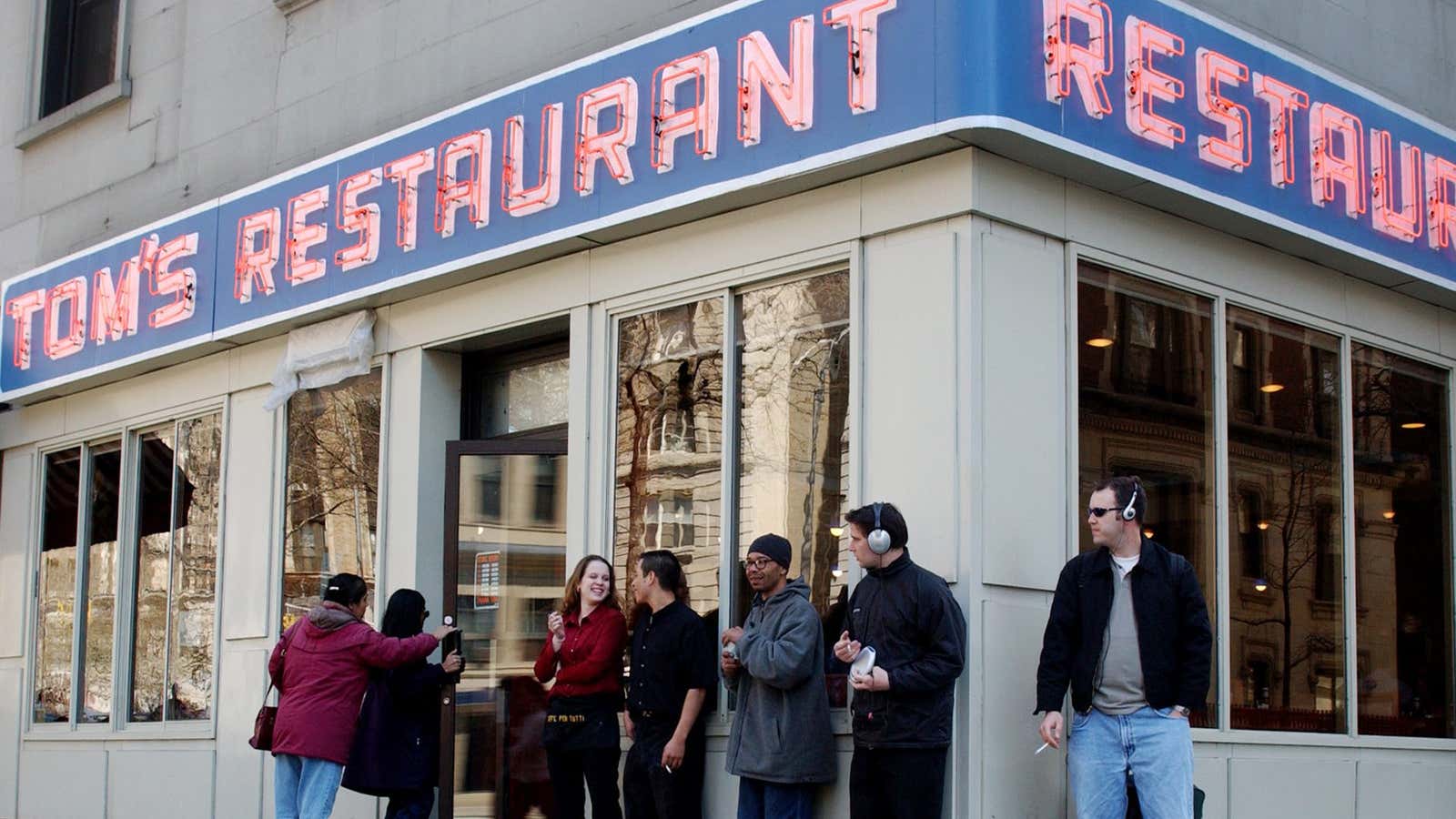 Sam Edwards, right, of Pittsburgh, Penn., a long time customer of Tom’s Restaurant in the Manhattan borough of New York, smokes outside the diner, Monday, March 29, 2004.  A new report says that in the first 10 months after New York City instituted a ban on smoking in public places, tax receipts from bars and restaurants jumped 8.7 percent.  (AP Photo/Jennifer Szymaszek)