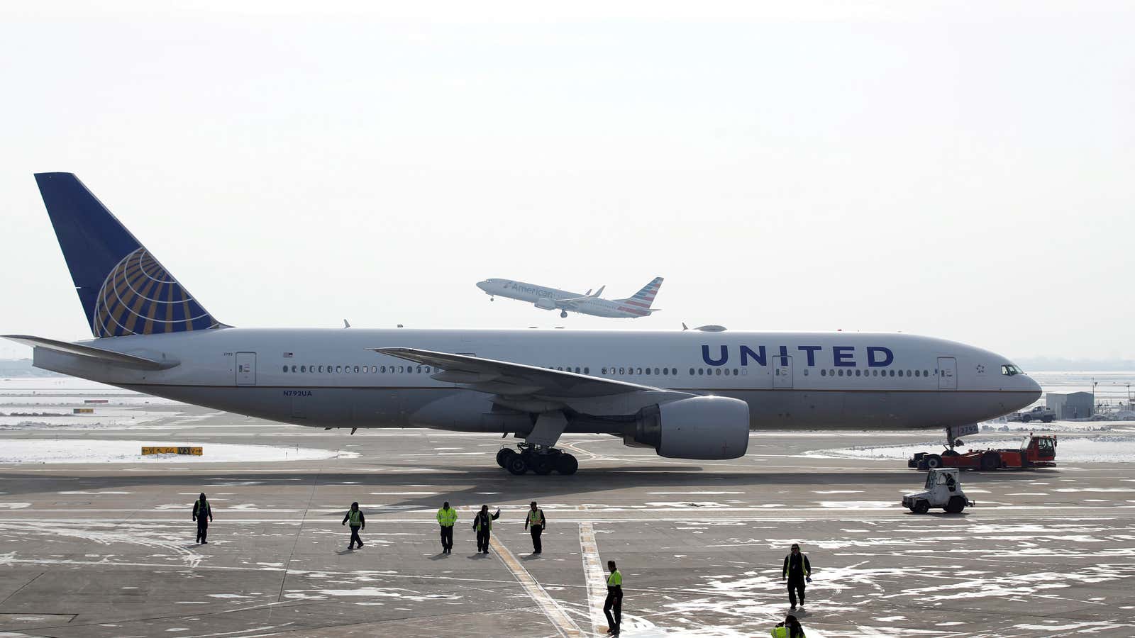 FILE PHOTO: A United Airlines Boeing 777-200ER plane is towed as an American Airlines Boeing 737 plane departs from O’Hare International Airport in Chicago, Illinois,…