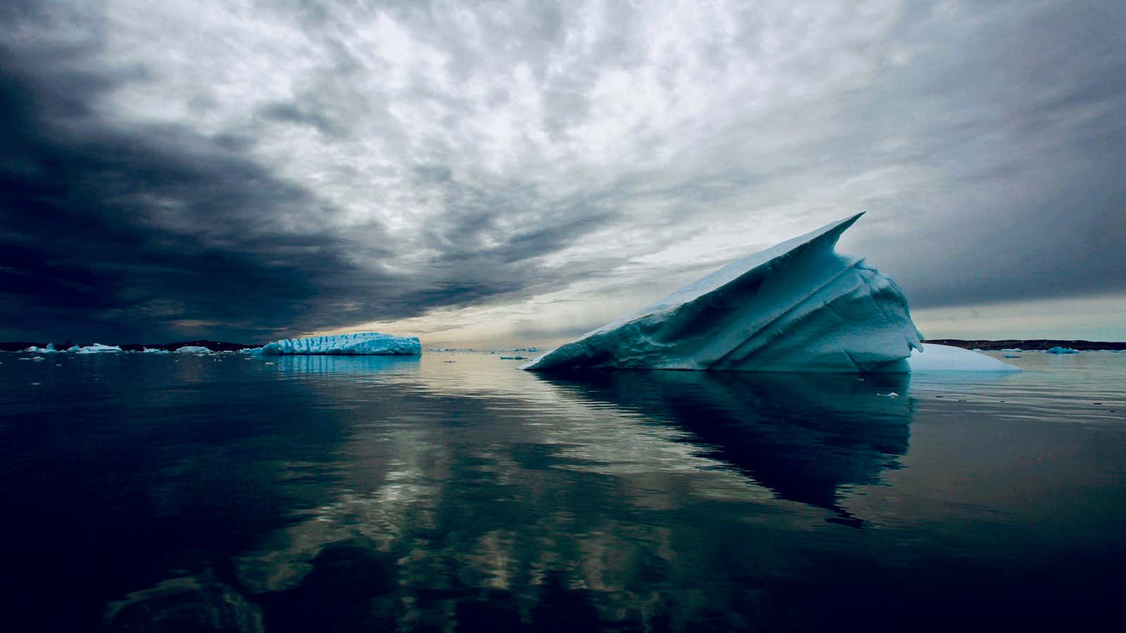 Icebergs float in the calm waters of a fjord, south of Tasiilaq in eastern Greenland August 4, 2009.  REUTERS/Bob Strong (GREENLAND ENVIRONMENT) – GM1E5850KKL01