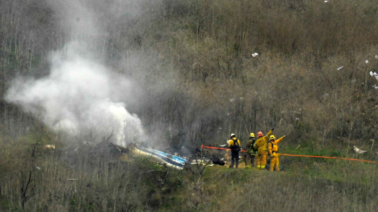 Firefighters work at the scene of the crash where former NBA star Kobe Bryant died.