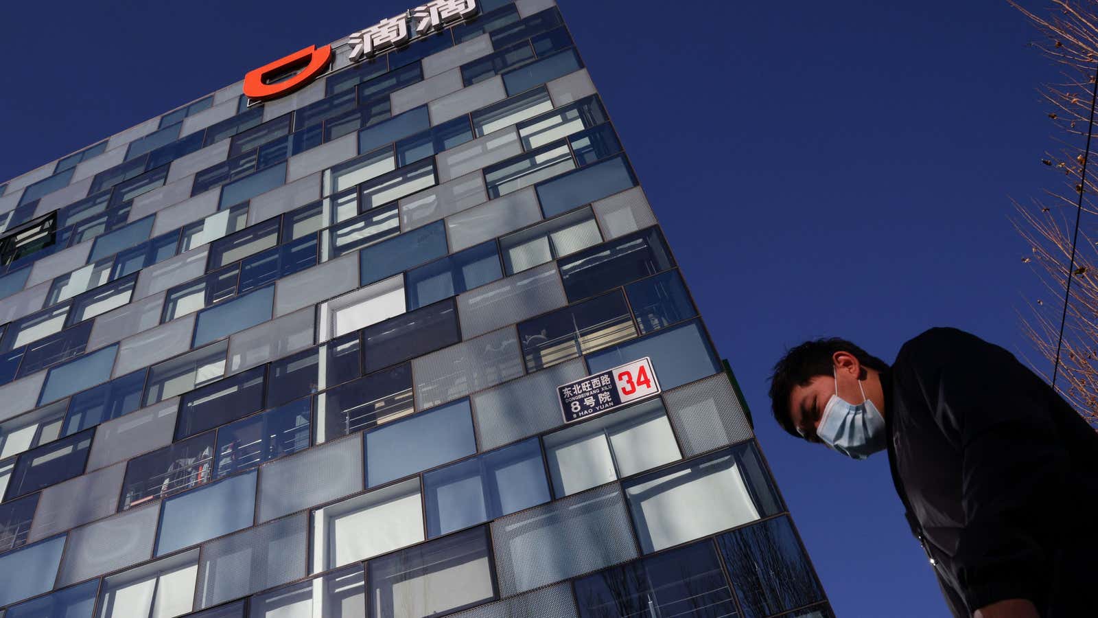 A man walks past the headquarters of the Chinese ride-hailing service Didi in Beijing, China, December 3, 2021.