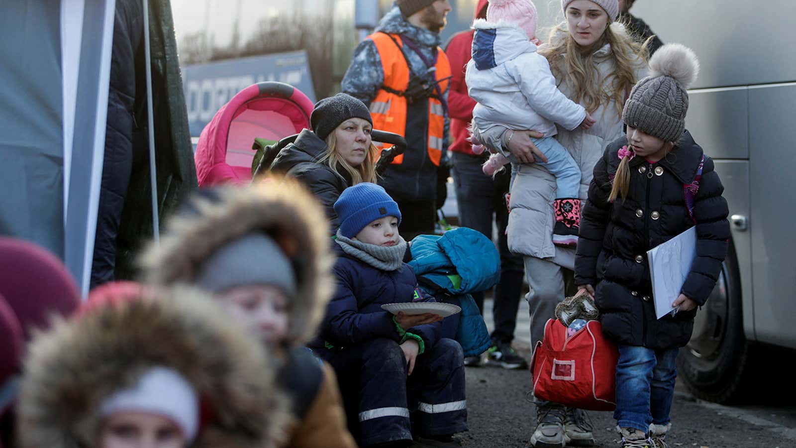 A person carrying a child walks as refugees from Ukraine cross the Ukrainian-Slovakian border following Russia’s invasion of Ukraine, in Vysne Nemecke, Slovakia, March 3, 2022. REUTERS/Lukasz Glowala