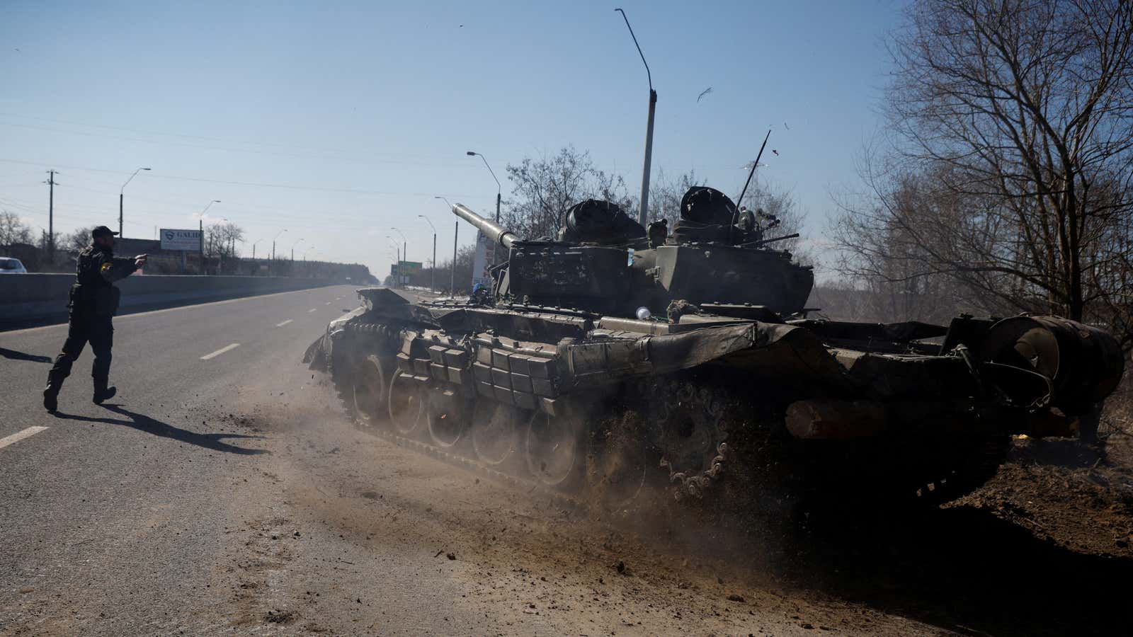 A Ukrainian soldier directs a Russian tank that Ukrainians captured.