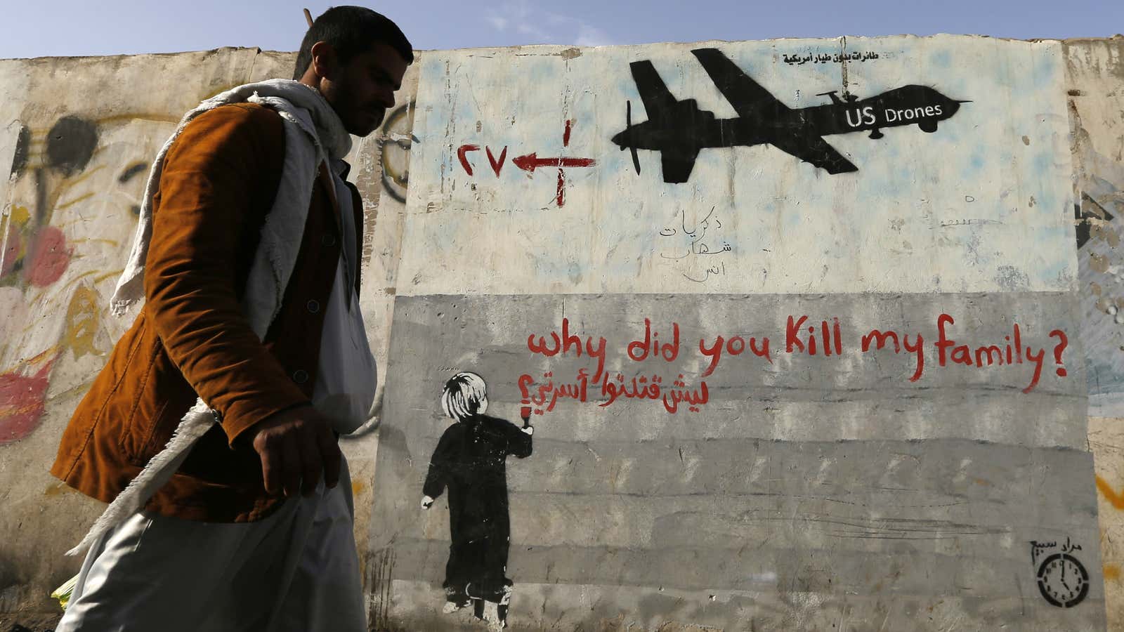 A man walks past a graffiti denouncing strikes by US drones in Yemen.