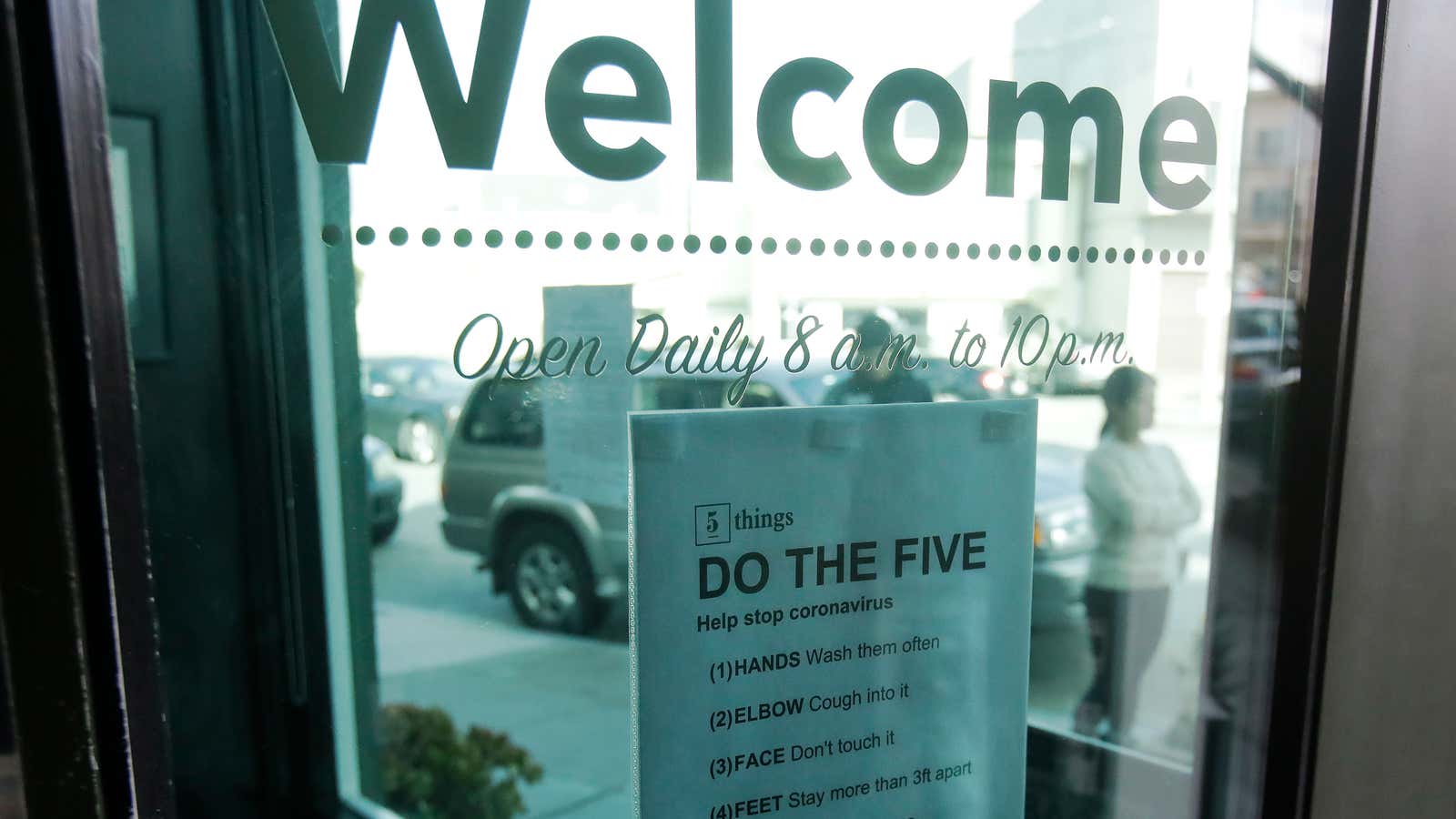 A sign about preventing the spread of the coronavirus is posted on the door of The Green Cross cannabis dispensary in San Francisco.