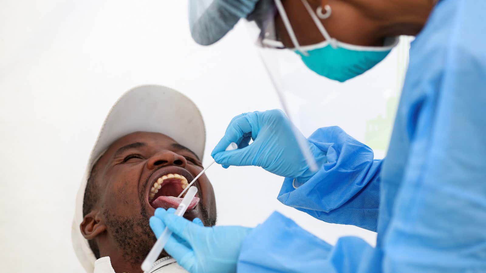 A medical worker takes a swab sample from a man in Diepsloot near Johannesburg, South Africa, May 8, 2020.