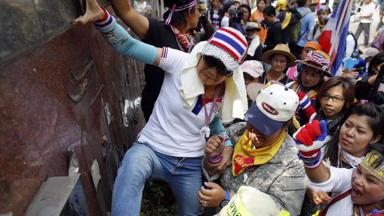 Anti-government protesters destroy a police station sign.