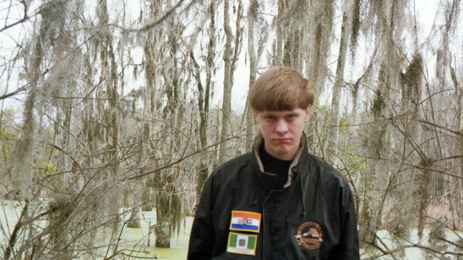 The flags on Roof’s jacket are of apartheid-era South Africa and Rhodesia.