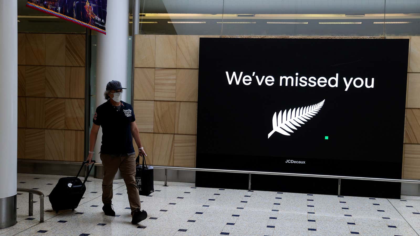 FILE PHOTO: A passenger arrives from New Zealand after the Trans-Tasman travel bubble opened overnight, following an extended border closure due to the coronavirus disease…