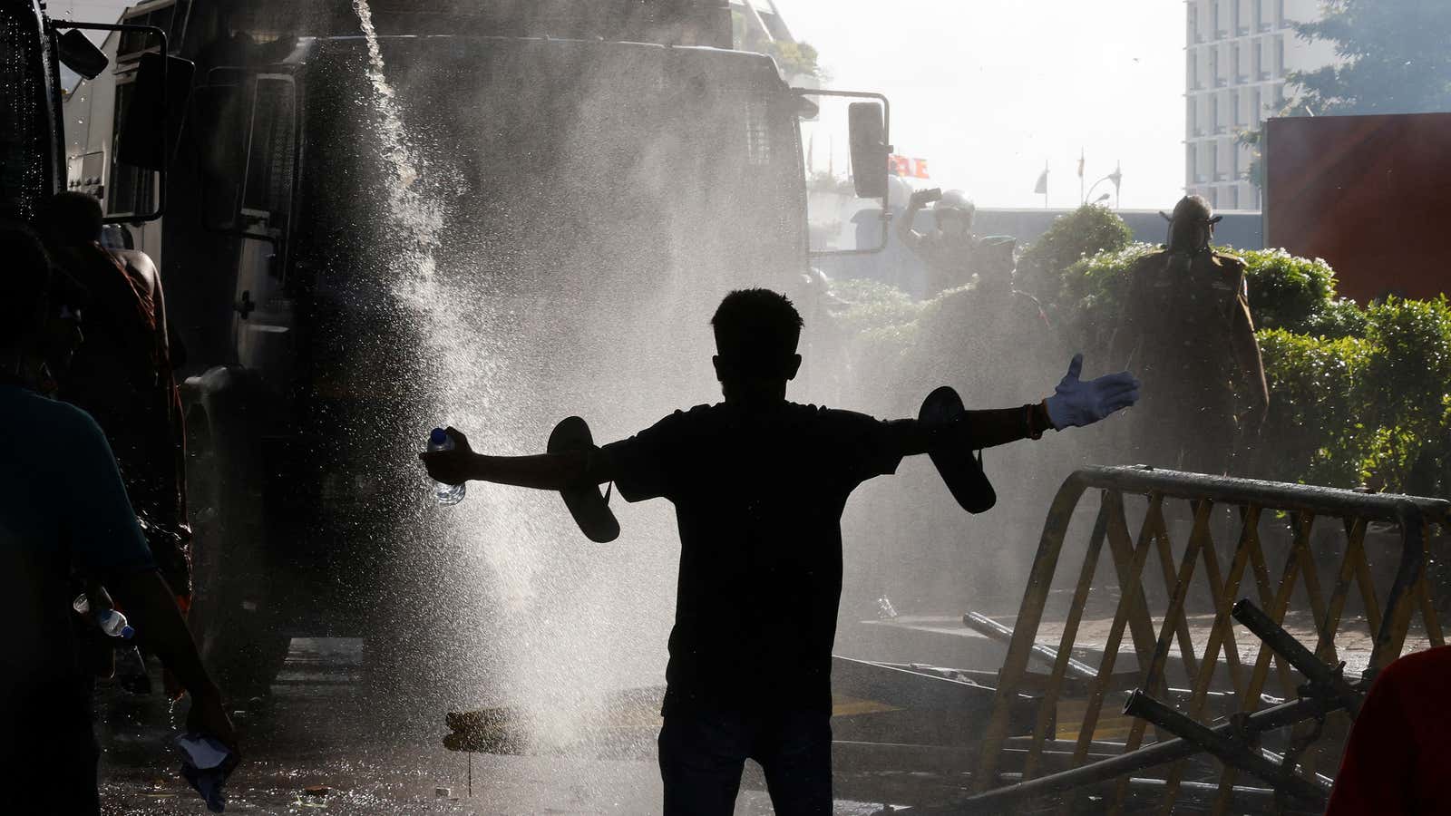 A protestor stands in front of a water cannon during a protest organized by students amid the economic crisis in Sri Lanka.