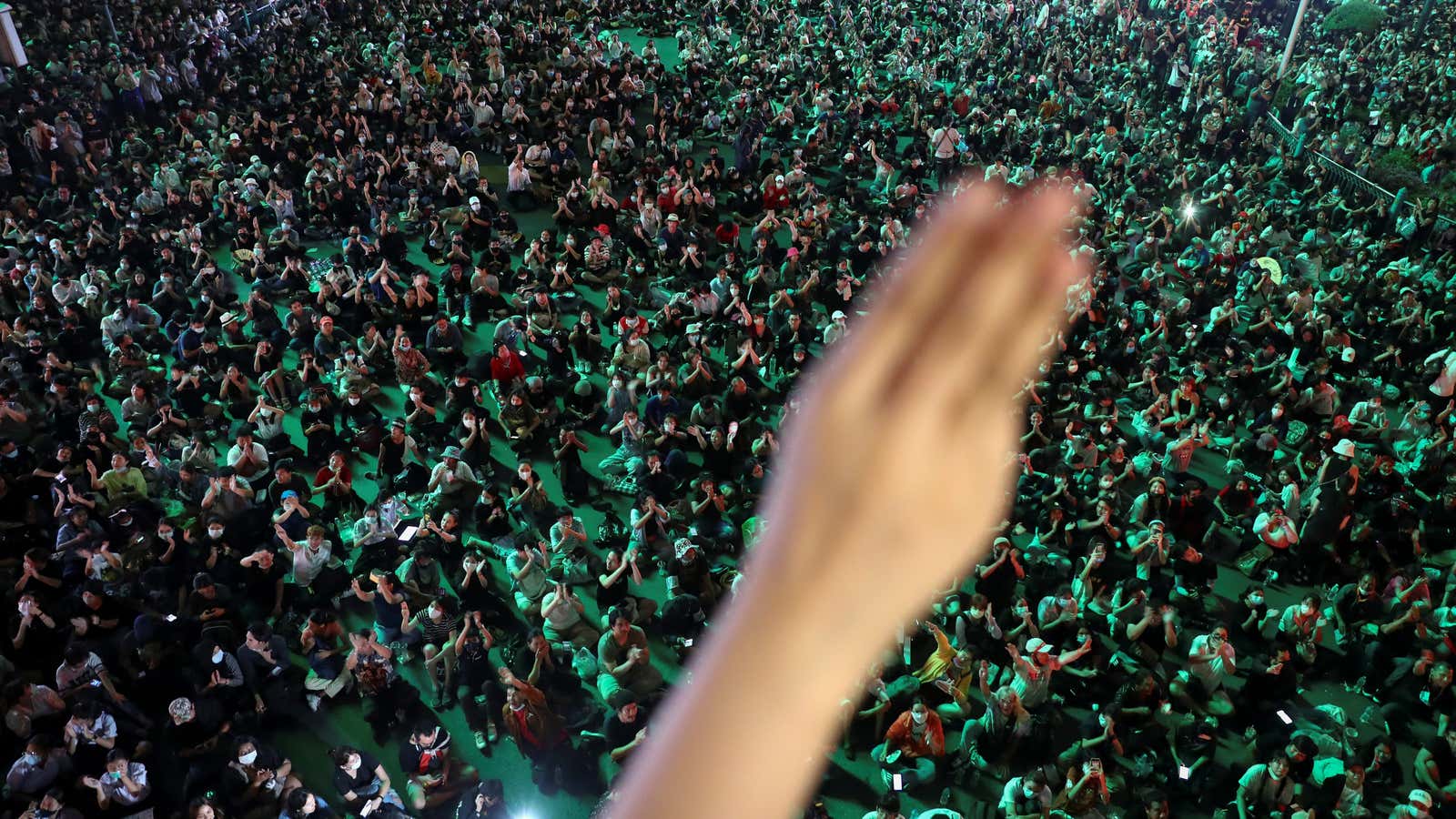 A person shows the three-finger salut as pro-democracy protesters gather demanding the government to resign and to release detained leaders in Bangkok, Thailand October 15,…