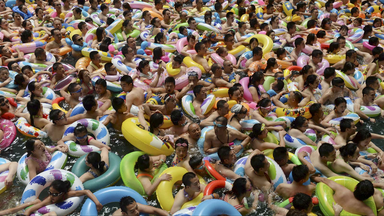 Visitors crowd an artificial wave swimming pool at a tourist resort to escape the summer heat in Daying county of Suining, Sichuan province, China.