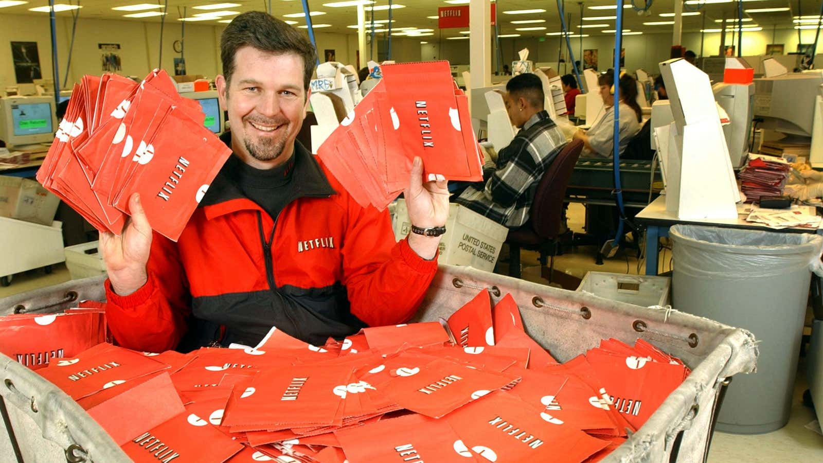 Netflix CEO Reed Hastings holding a batch of mail-in DVDs in 2002.