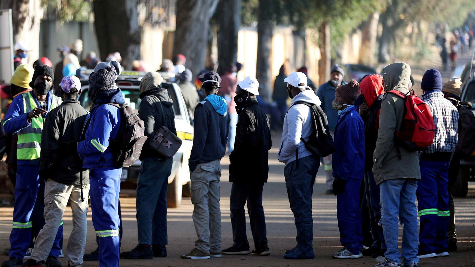 Job seekers stand outside a construction site in Johannesburg. A new book asks why the coronavirus pandemic has increased inequality instead of reducing it, like previous pandemics.