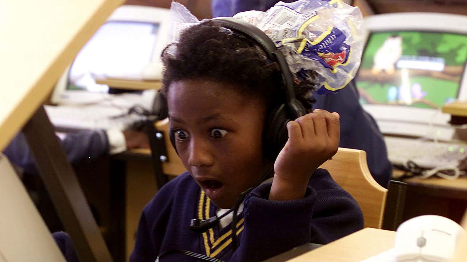 Eight year old Jenni-Lee Mason stares in awe as she uses a computer for the first time at a township school in Cape Town, August…