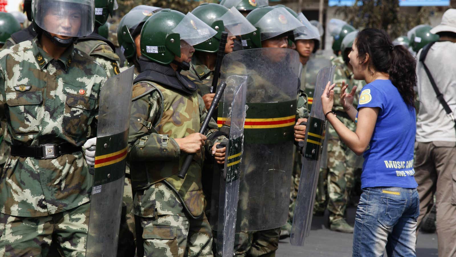 An Uighur woman shouts at riot police attempting to quell ethnic violence in Xinjiang province in 2009.