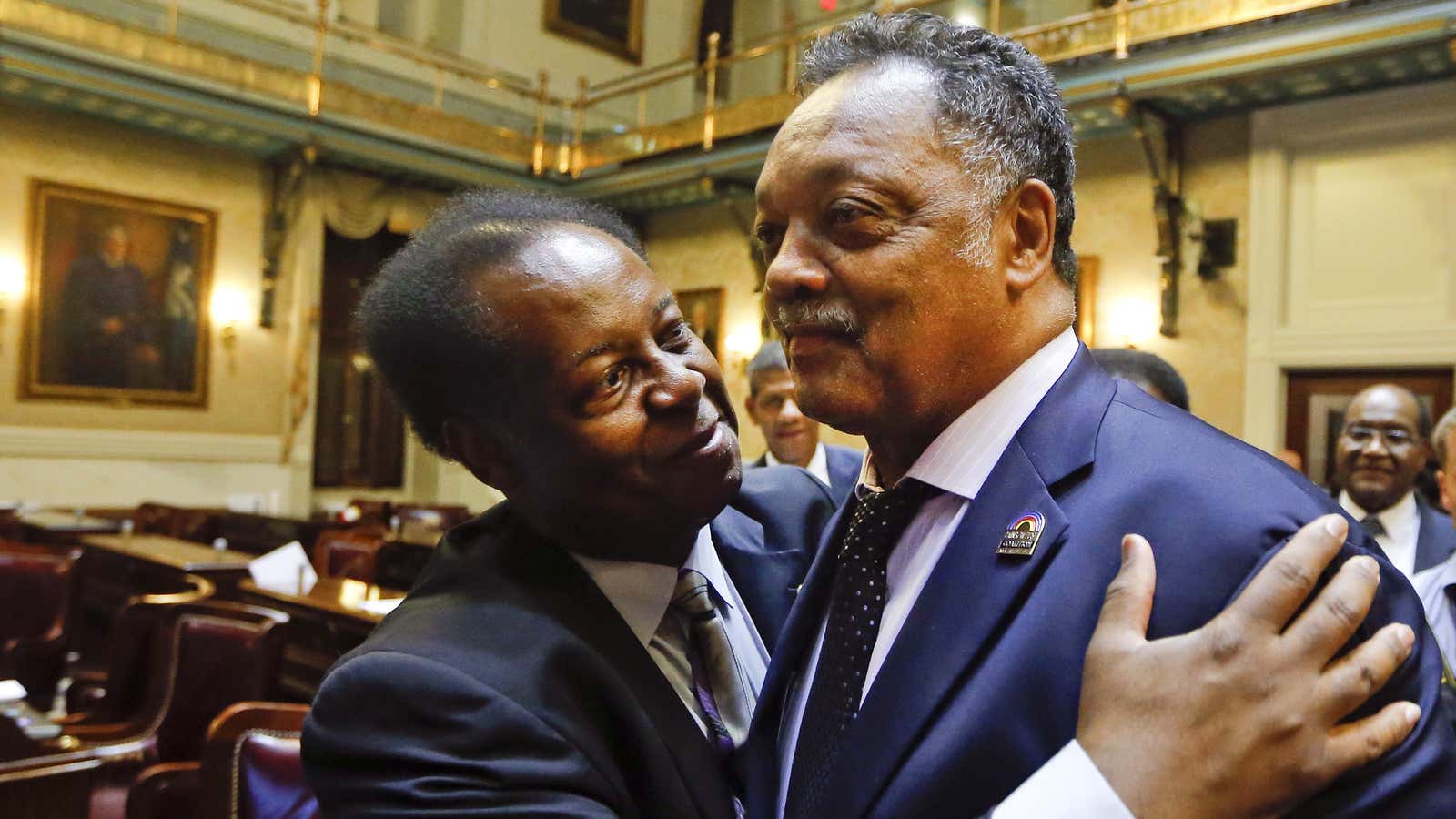 Rep. Carl Anderson, left, embraces Rev. Jesse Jackson.