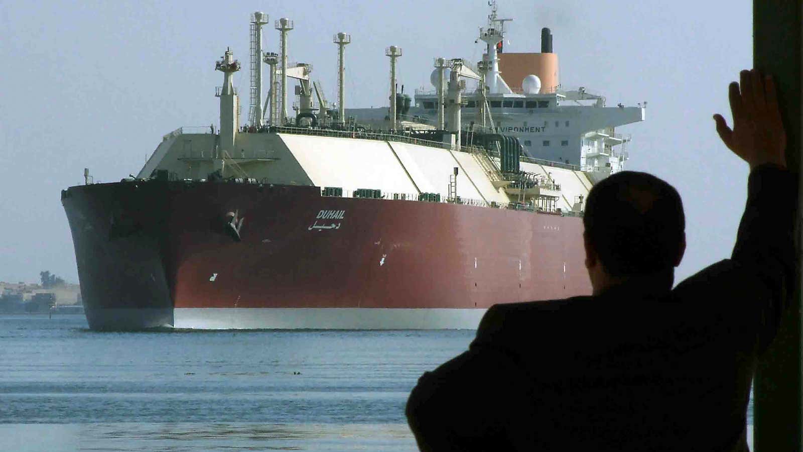 A tanker carrying natural gas steams through the Suez Canal. Egypt is cutting its own electricity use in order to export more natural gas.