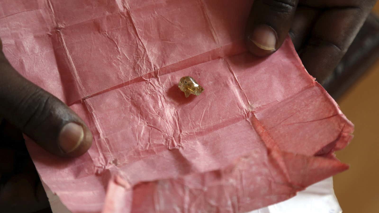 A man displays a rough diamond, from the Boda region, for sale in Bangui, CAR, May 1, 2014.