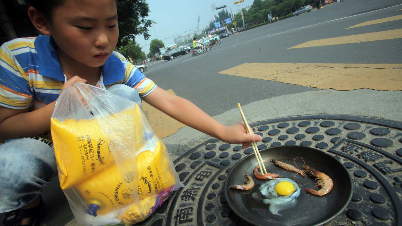 Short-order cook: A child in Jinan, part of China’s Shandong province, grills raw shrimp and an egg.