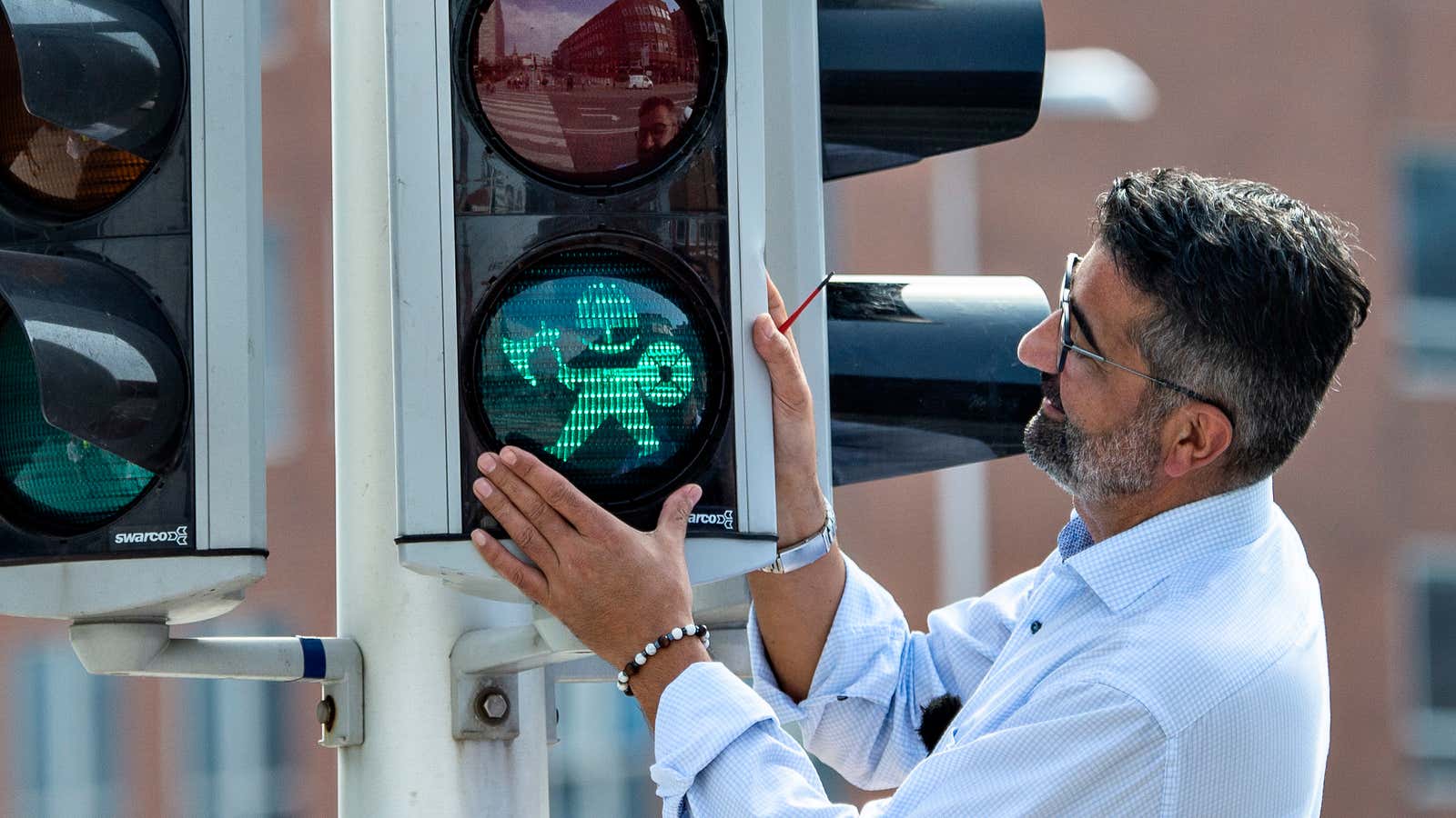 Mayor Bunyamin Simsek replaces the first of the many pedestrian signals with Vikings lights, on Aug. 26, in Aarhus, Denmark.