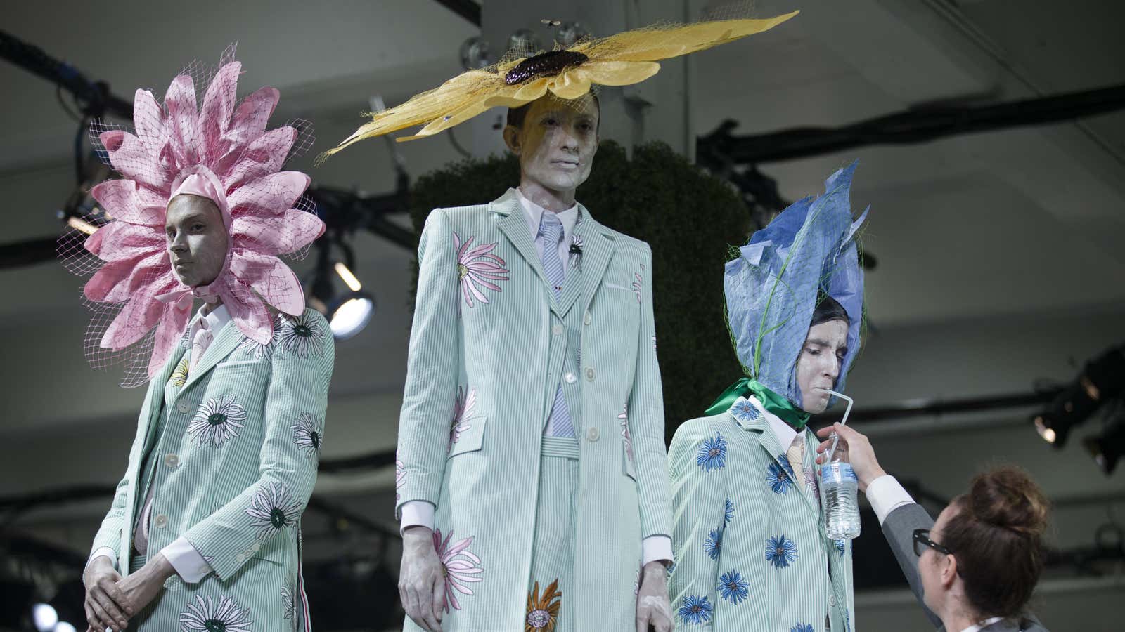 A flower is watered at Thom Browne’s Spring 2015 show.