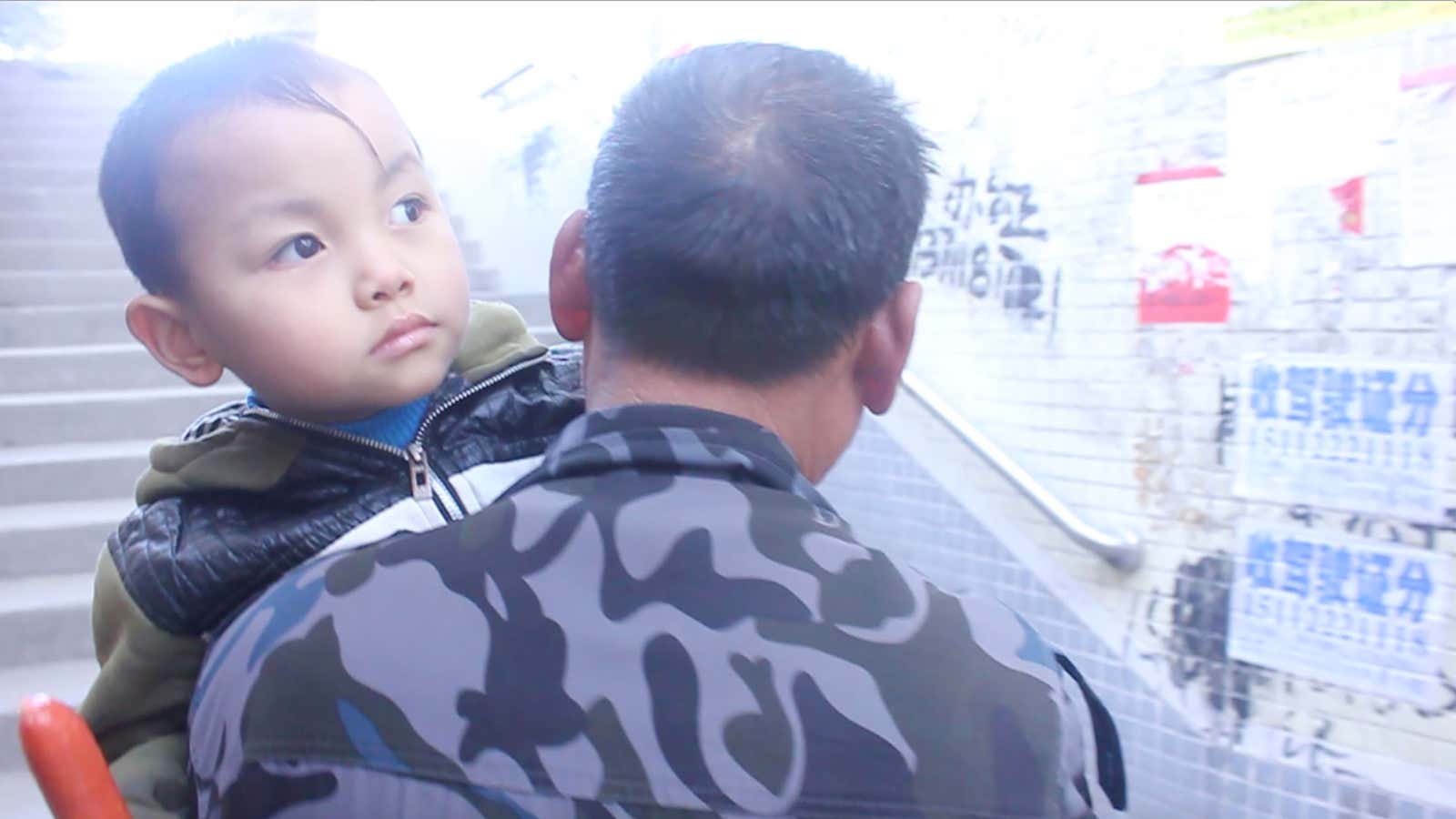 Migrant child Zou Ziyi being carried by his grandfather.