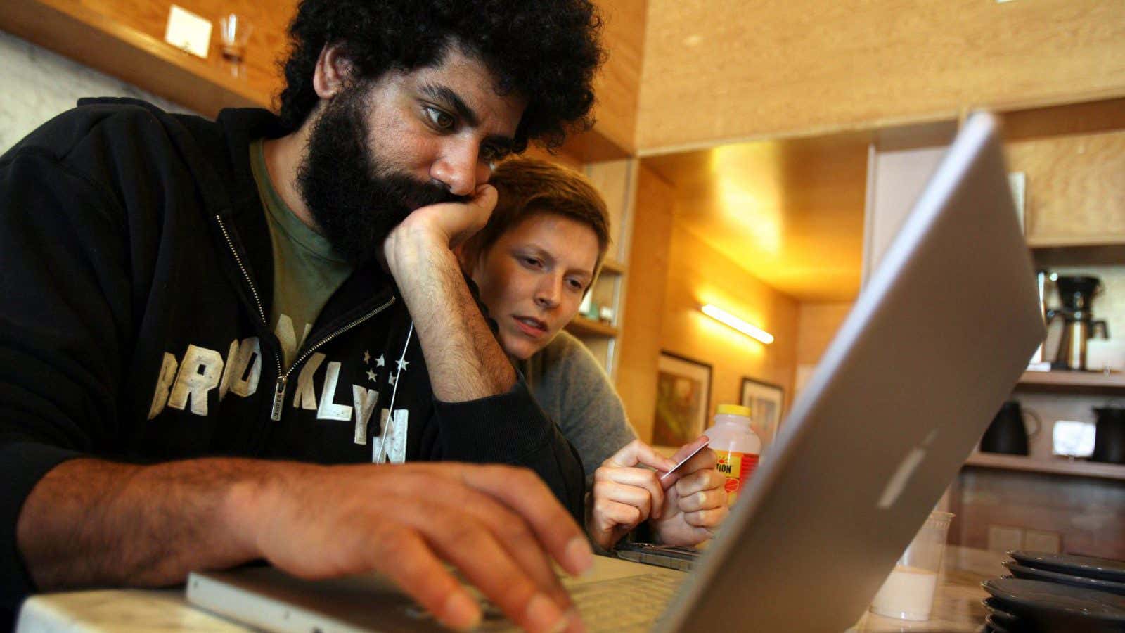 Writer and actor Mousa Kraish, left, looks at his computer with friend Deanna Mustard at the Intelligentsia coffee shop in Los Angeles, Wednesday Feb. 13,…