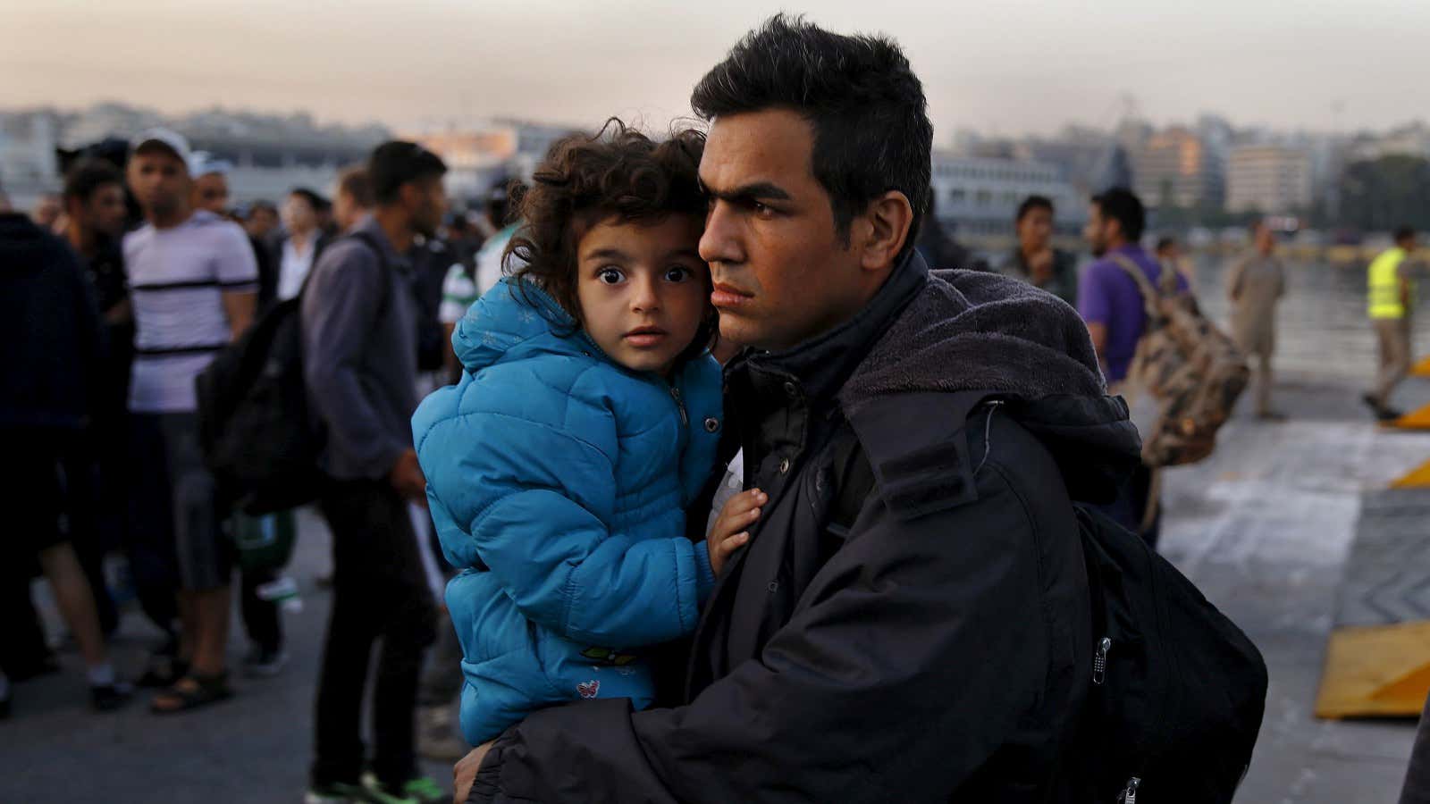 A Syrian man and child disembarking in Greece.