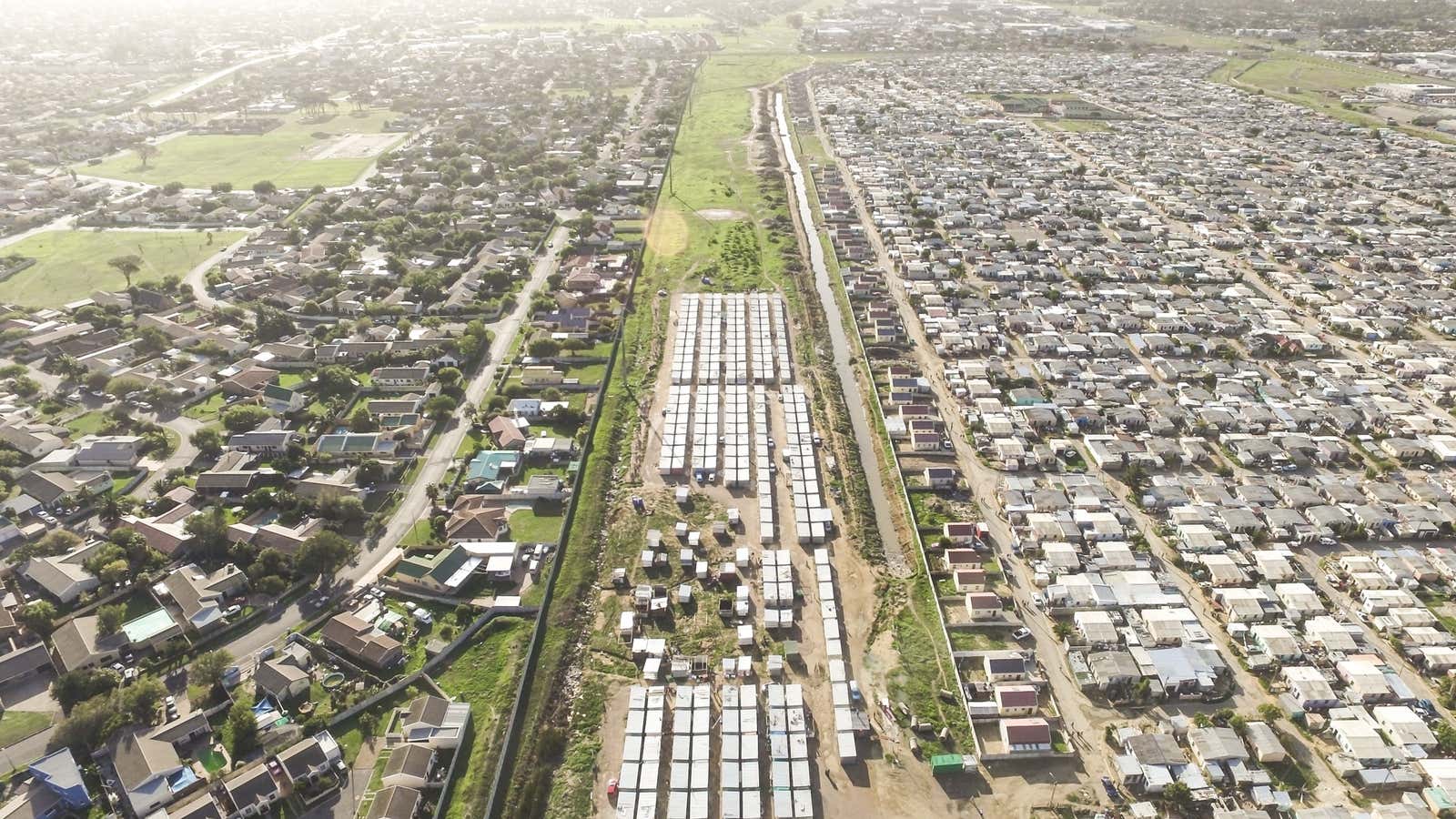 A drone view of the neighborhoods of Strand and Nomzamo in Cape Town.