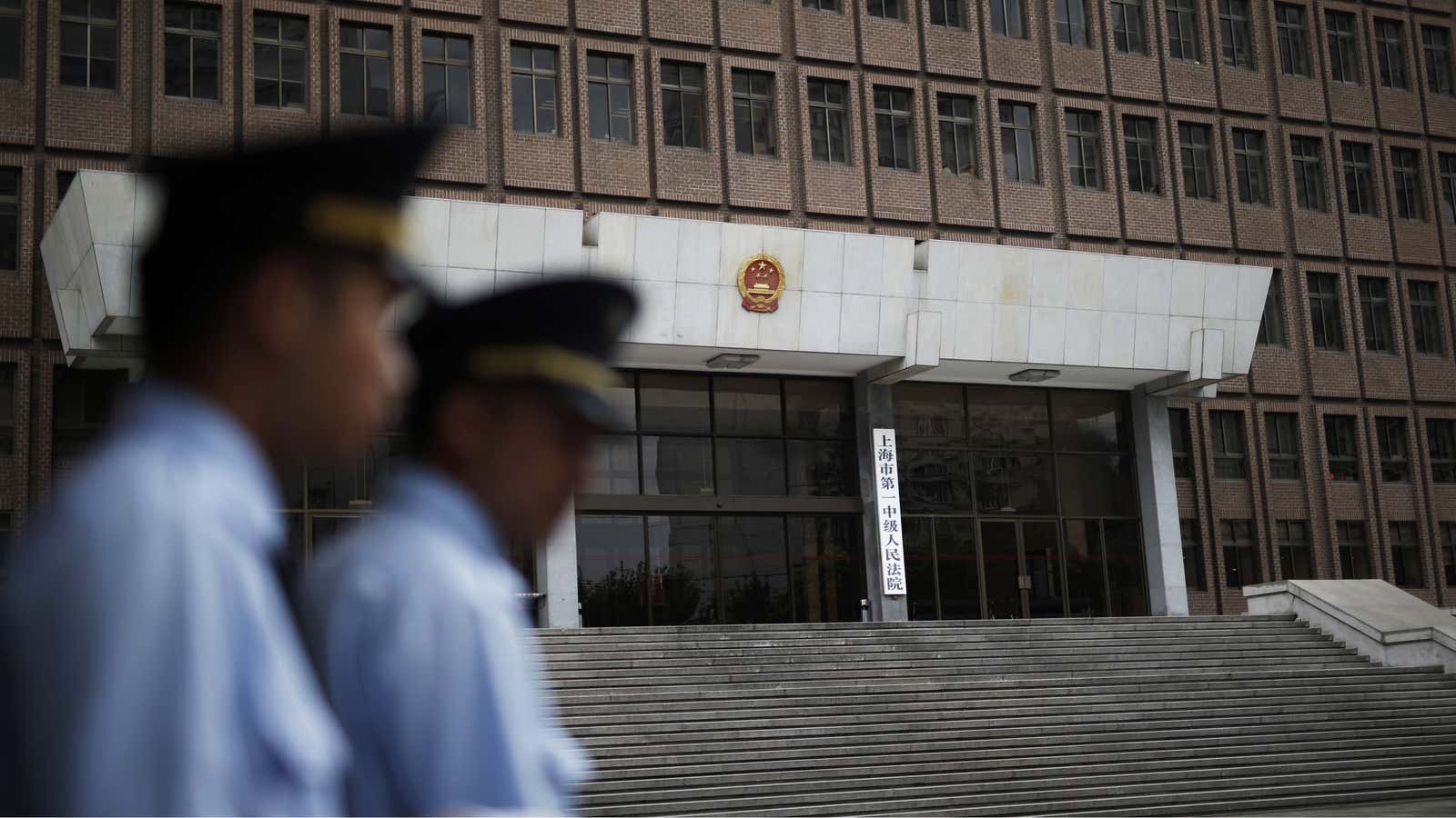 Police patrol outside the Shanghai No.1 Intermediate People’s Court, where two GSK contractors faced charges of illegally obtaining private information on Chinese citizens.