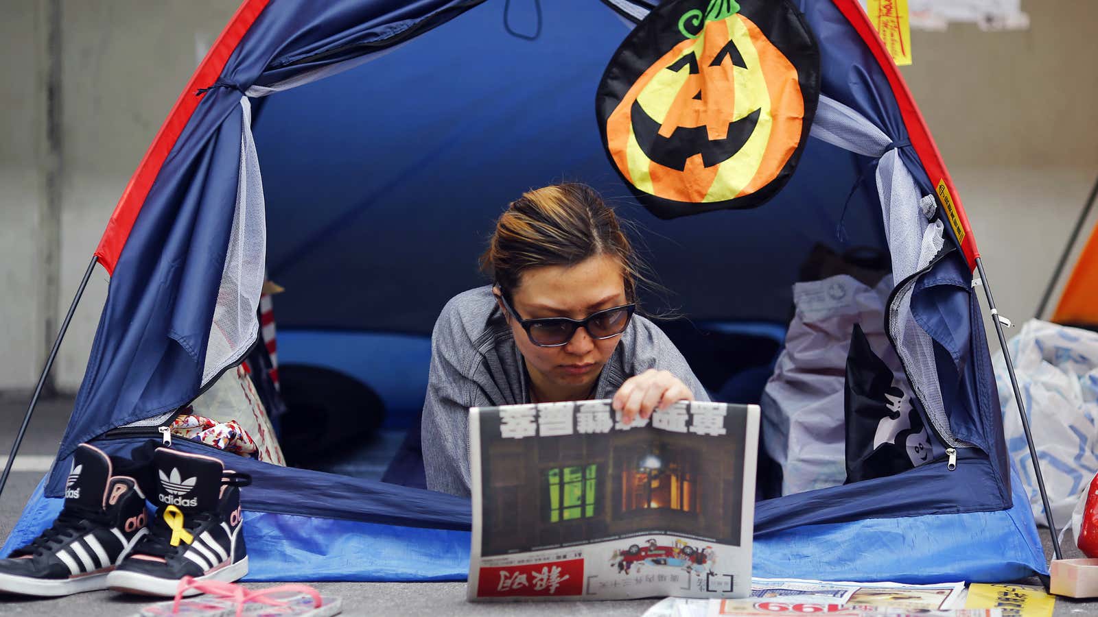 A protester reads a newspaper during the Occupy Central protests in November 2014.