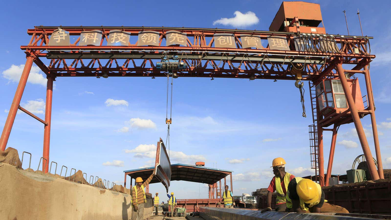 Workers under a sign written in Chinese during the construction of the Mombasa-Nairobi railway at Emali in Kenya October 2015.