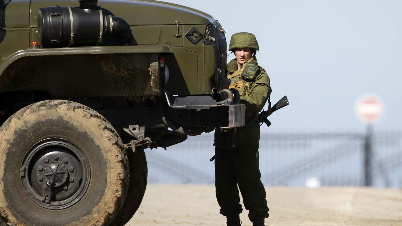 A soldier, believed to be a Russian serviceman, stands guard near a local airfield in the village of Lyubimovka, southwest of Simferopol, Crimea’s capital.