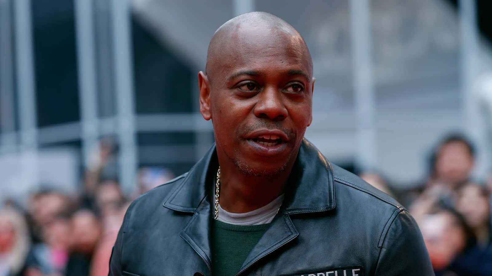 Actor Dave Chappelle in a black leather jacket