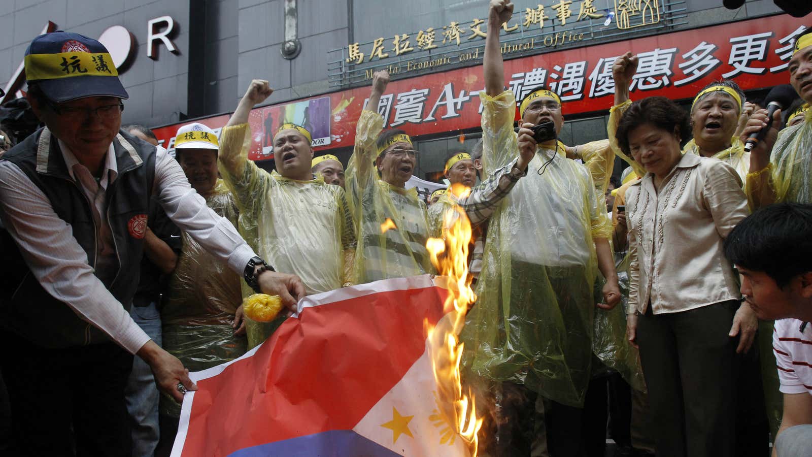 Protesters and lawmakers burn the Philippine flag in the Taiwanese capital.