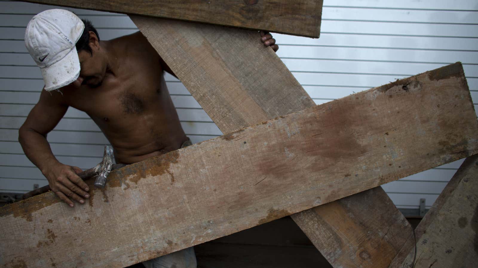 A worker boards up the front of a waterfront business in Puerto Vallarta.