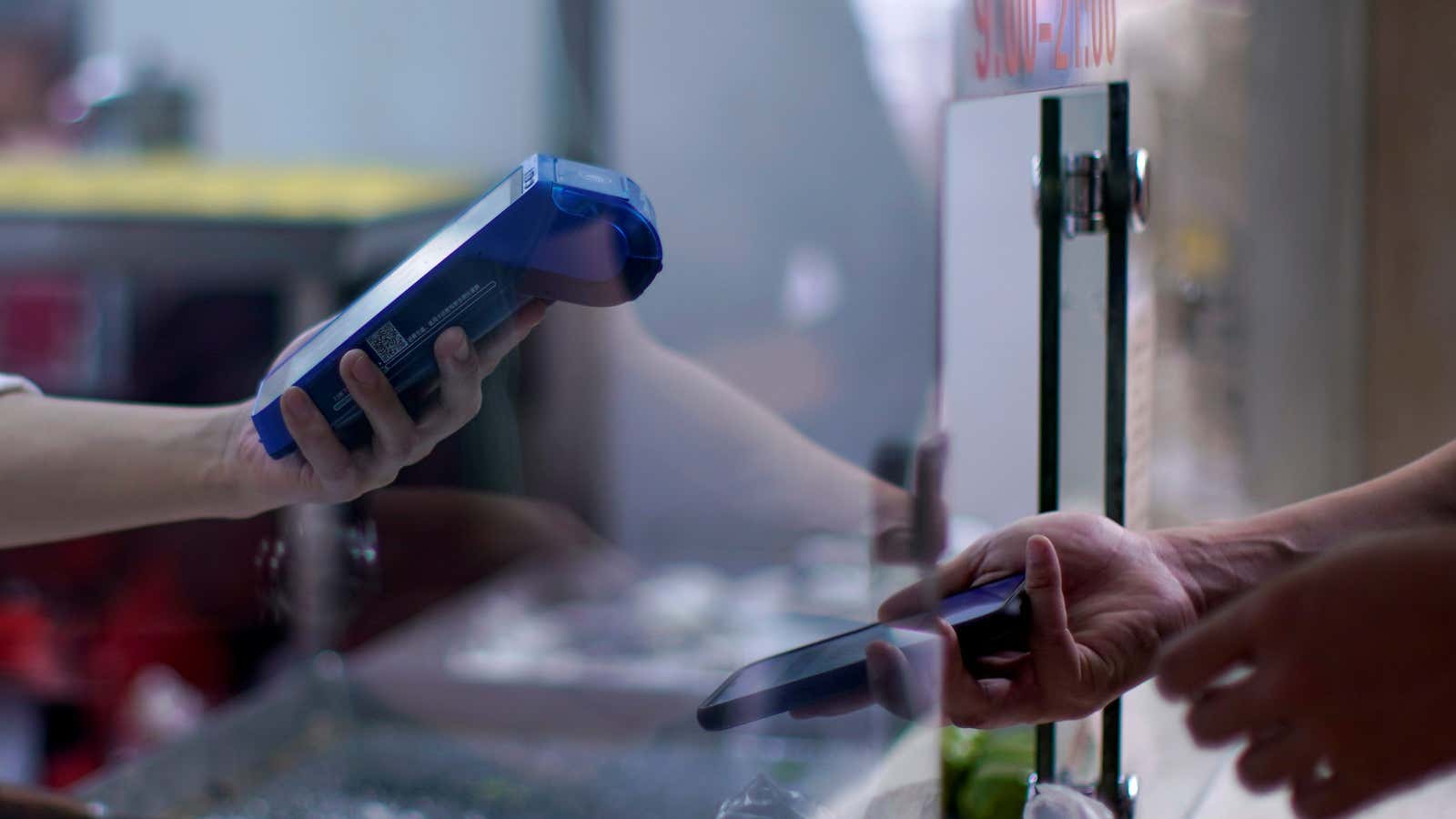 A person gets a scan of a phone’s QR code of the digital payment services at a food shop, following the coronavirus disease (COVID-19) outbreak,…