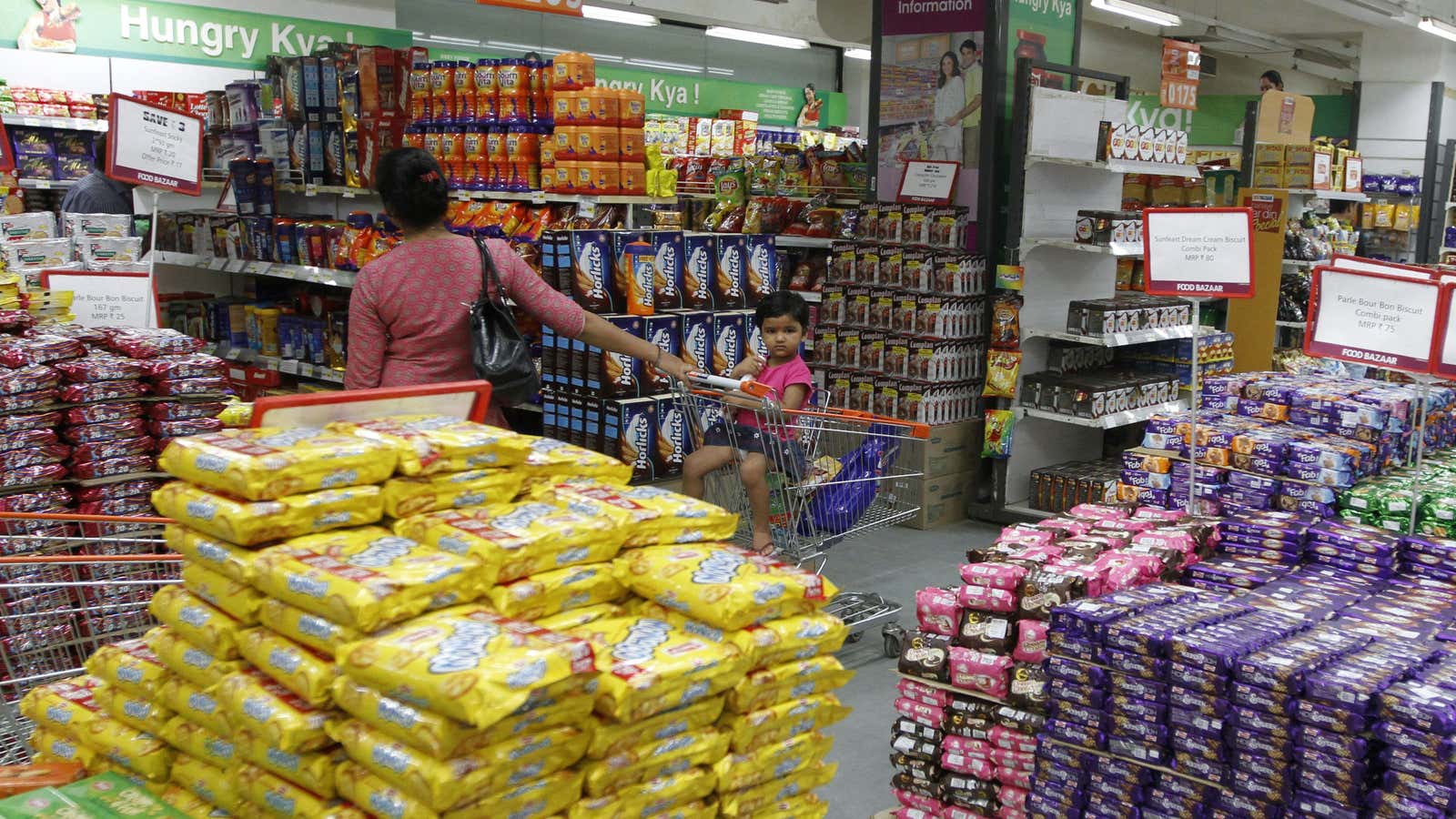 A girl sits in a shopping trolley as her mother shops inside a food superstore in the western Indian city of Ahmedabad September 14, 2012.…