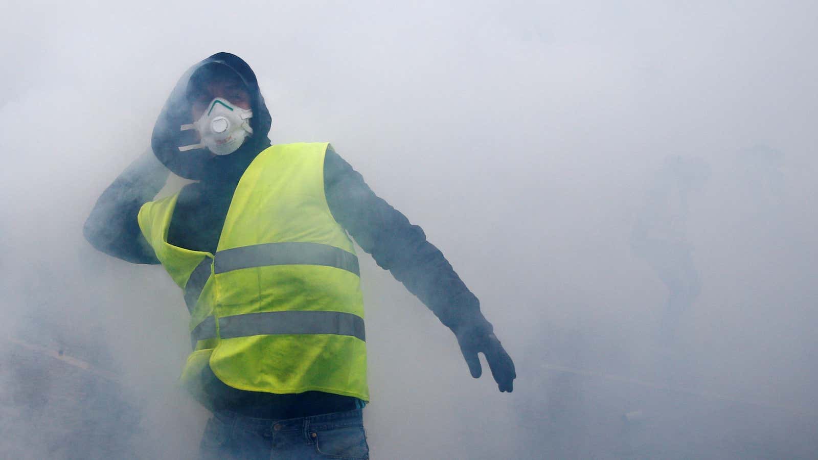 Tear gas fills the air as a protester wearing a yellow vest, a symbol of a French drivers’ protest against higher diesel taxes, demonstrates near the Place de l’Etoile in Paris, France, December 1, 2018. REUTERS/Stephane Mahe – RC1575EE0850