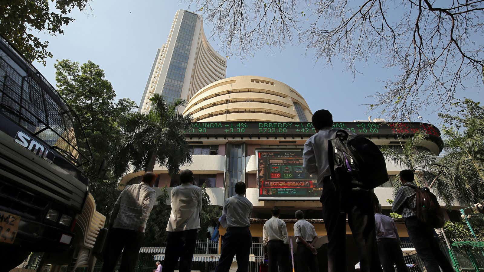 People look at a screen displaying the Sensex results on the facade of the Bombay Stock Exchange (BSE) building in Mumbai, India, December 11, 2018.