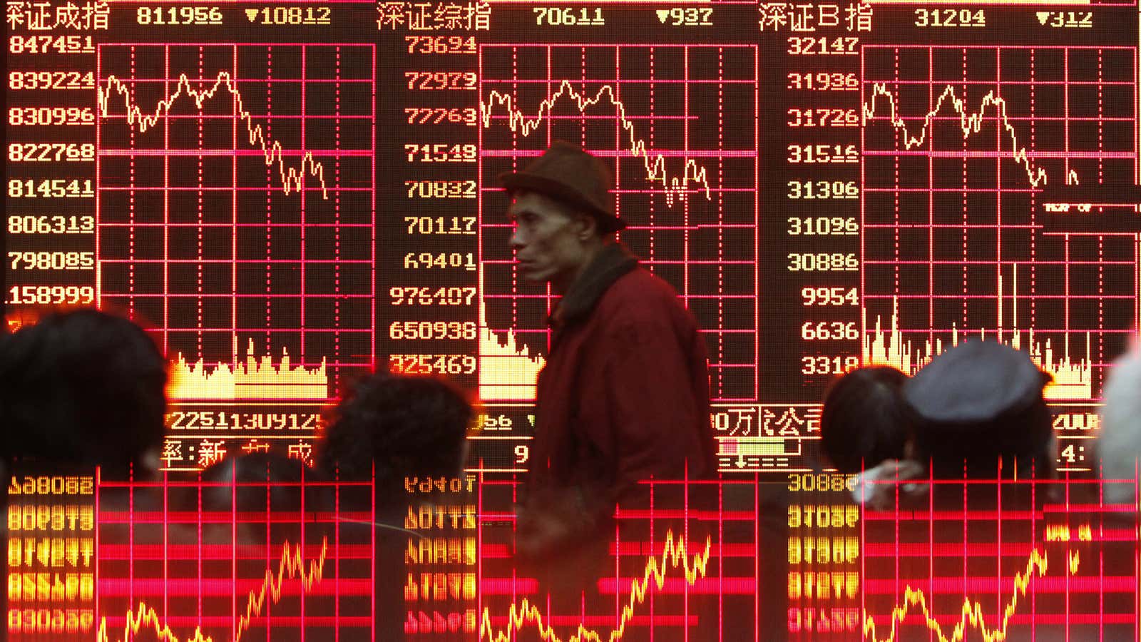 A man walks in front of a stock ticker board at a Shanghai brokerage.