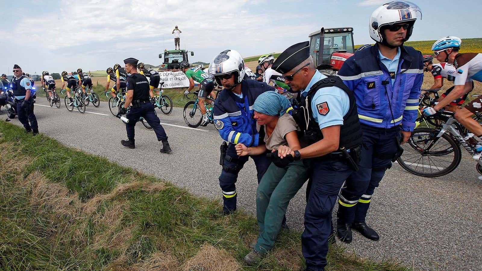 Police carry a protester off the road.